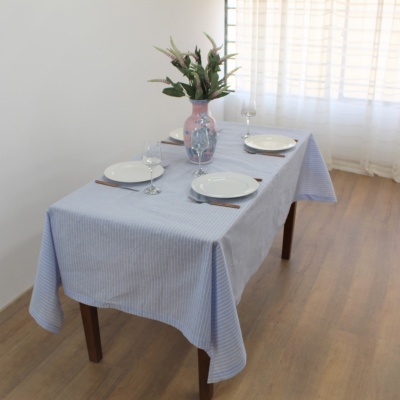 Mesa posta com toalha azul e decoração floral