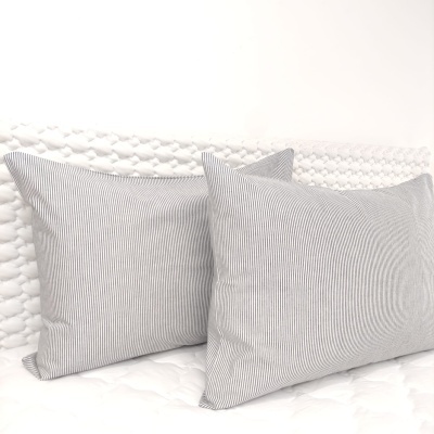 Duas almofadas riscas cinzentas numa cama branca texturada