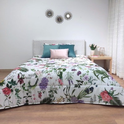 Cama de casal com edredão floral e almofadas coloridas em quarto minimalista.