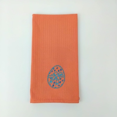 Pano de cozinha laranja com desenho azul de ovo de Páscoa