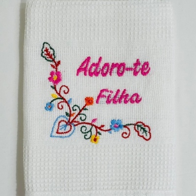 Toalha branca com bordado colorido e frase em rosa