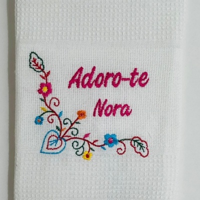 Toalha branca bordada com texto e flores coloridas