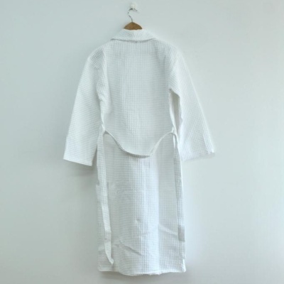 Robe branco de tecido com padrão de quadrícula pequena pendurado numa cabide