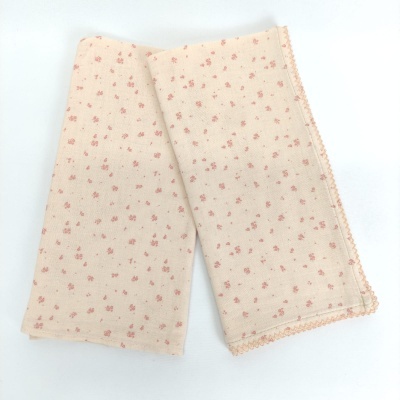 pano bege claro com pequenas flores cor de rosa e acabamento festão