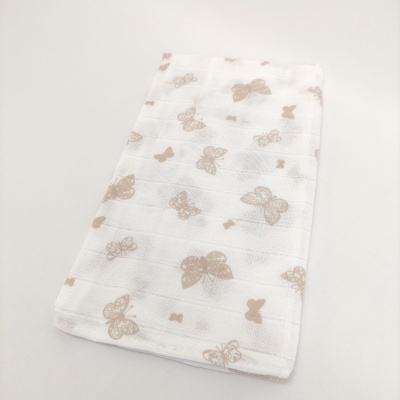 Toalha branca com padrão de borboletas bege dobrada