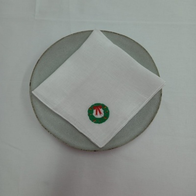 Guardanapo branco com bordado de coroa de flores e prato cinzento