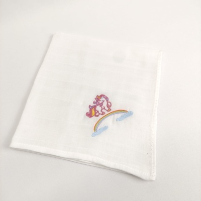 Fralda branca com bordado de unicórnio sobre arco-íris e nuvens