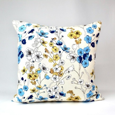 Almofada branca com padrão floral azul, amarelo e preto