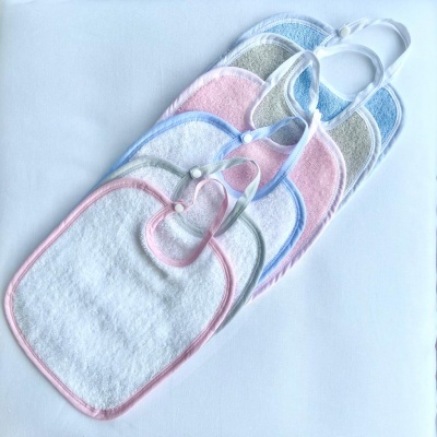 Babetes de tecido com bordas coloridas e fecho de botão