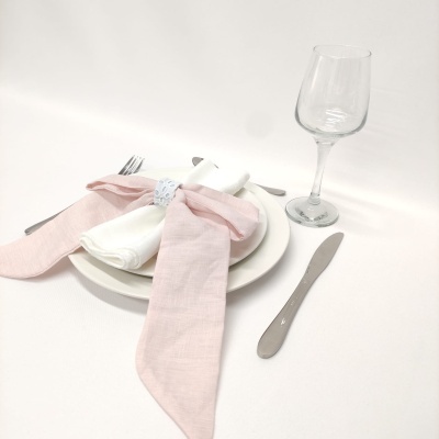 Conjunto de jantar com guardanapos e talheres sobre fundo branco.