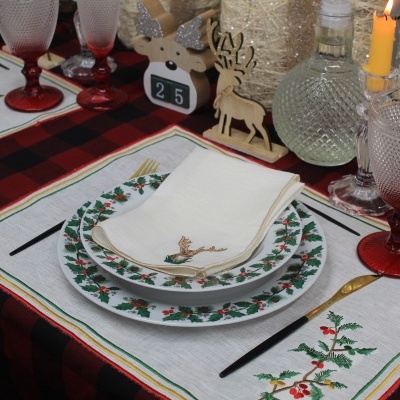 Mesa posta com conjunto de jantar e decoração natalícia