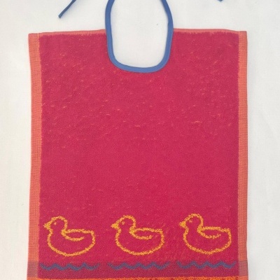 Babete vermelho com patos amarelos e padrão geométrico