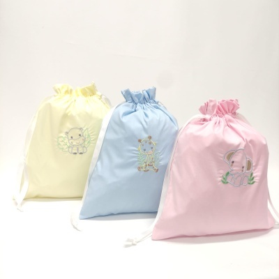 Três sacos de tecido amarelo, azul e rosa com bordados de animais