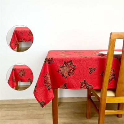 Toalha de mesa vermelha com padrão de folhas e arabescos sobre mesa de madeira