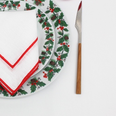 Pratos decorados, guardanapo branco e faca com cabo de madeira