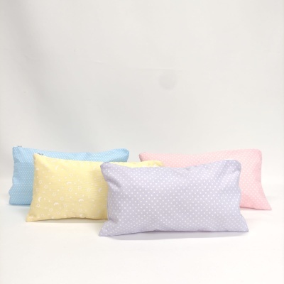 Conjunto de quatro almofadas retangulares em cores pastel com padrão de pontos brancos