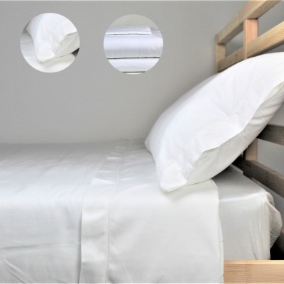 Cama de madeira com lençóis brancos