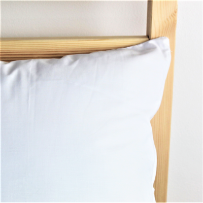 Almofada branca numa estrutura de madeira clara