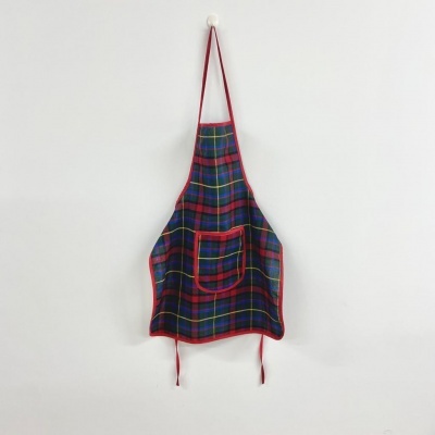 Avental com padrão xadrez colorido e bolso frontal pendurado na parede