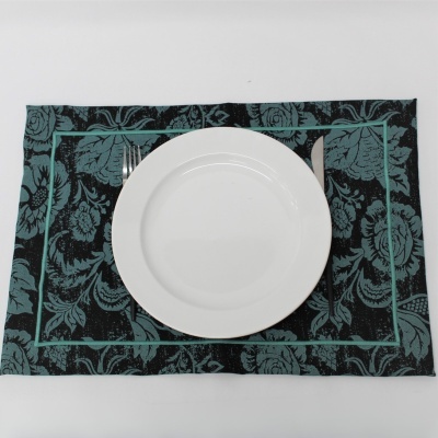 Guardanapo floral verde e preto com prato branco e talheres