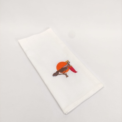 Guardanapo branco com bordado de pássaro com chapéu laranja e cachecol vermelho
