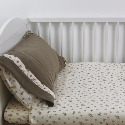 Berço branco com colchão e almofada em tecidos estampados e castanhos