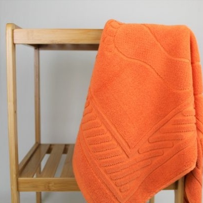 manta laranja pendurada em cadeira de madeira clara