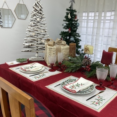Mesa de jantar decorada para Natal com toalha vermelha e decoração festiva