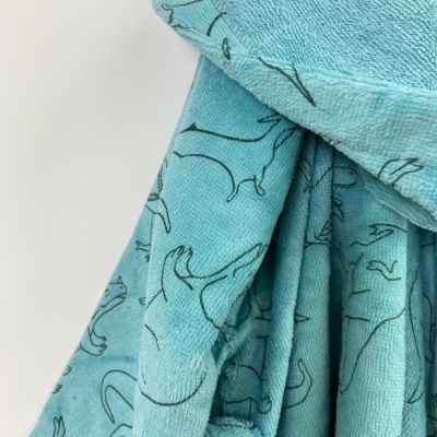 Manta azul turquesa com desenho de bichos em preto pendurada