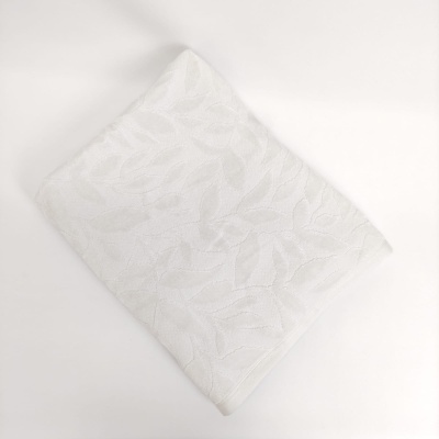 Toalha branca texturizada com padrão de folhas