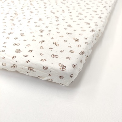 Colchão com capa branca e padrão castanho claro de folhas e flores