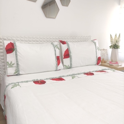 Jogo de cama branco com padrão de papoilas vermelhas e folhas verdes