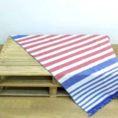 Manta riscada vermelha, branca e azul sobre plataforma de madeira.