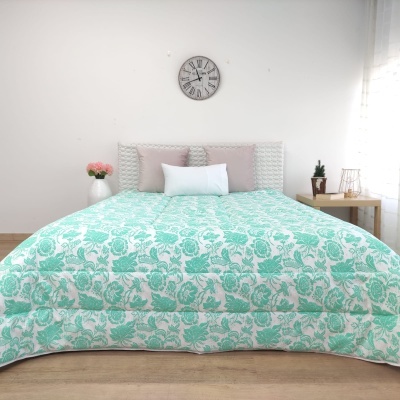 Cobertor de cama verde água floral com almofadas e relógio na parede