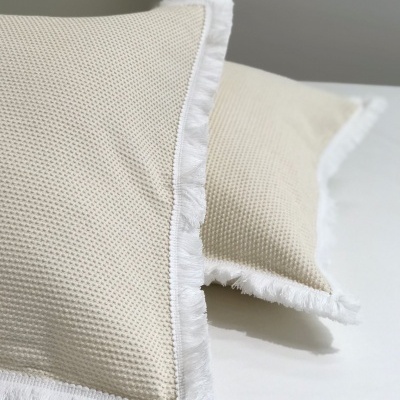 Duas almofadas bege com bordas brancas frisadas