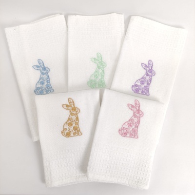 Cinco toalhas brancas com bordados coloridos de coelhos