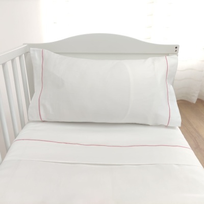 Cama de bebé branca com roupa de cama branca e linhas vermelhas finas