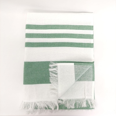 toalha branca com riscas verdes e franjas