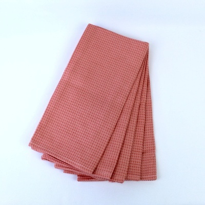 Pano de cozinha rosa com padrão quadriculado dobrado