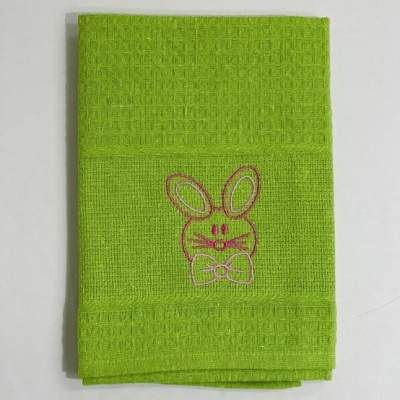 Toalha de mão verde com bordado de coelho rosa.