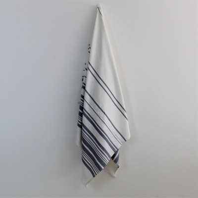 Toalha branca com riscas azuis pendurada na parede