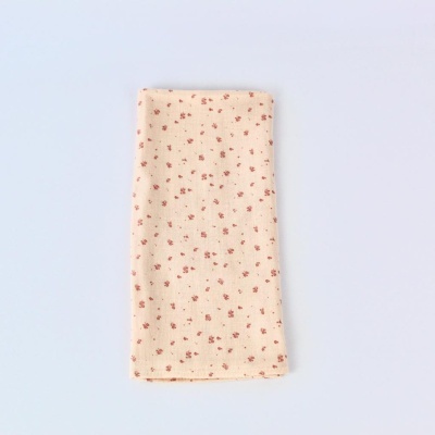 Lenço bege claro com pequenas flores vermelhas sobre fundo branco