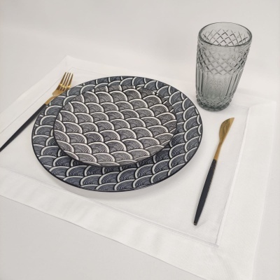 Conjunto de pratos, talheres, copo e guardanapo em fundo branco