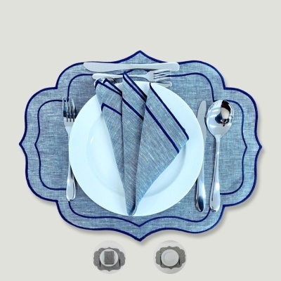 Conjunto de mesa com toalha cinzenta borda azul, prato branco e talheres prateados