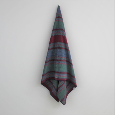 Toalha às riscas pendurada numa parede branca.