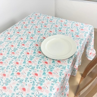 Toalha de mesa floral com prato branco sobre mesa e cadeiras de madeira