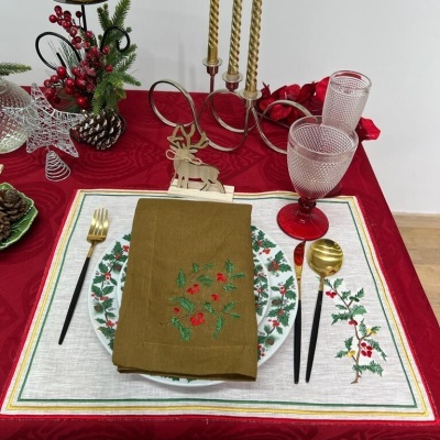 Mesa posta com decoração e utensílios de Natal em tons vermelhos, verdes e dourados.