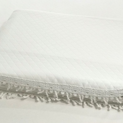 Manta branca acolchoada com franjas decorativas