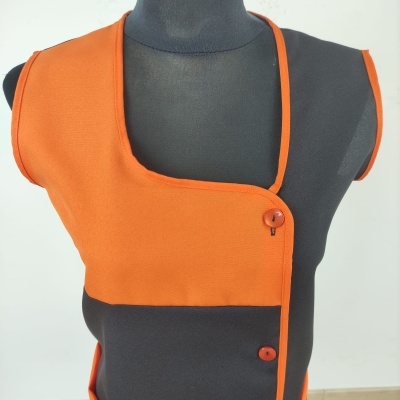 Roupa laranja assimétrica com botões em manequim preto