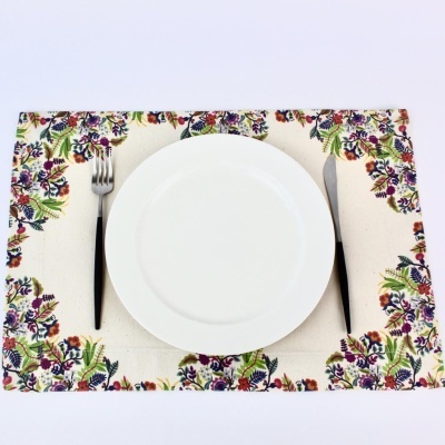 Jogo americano com padrão floral, prato branco, garfo e faca